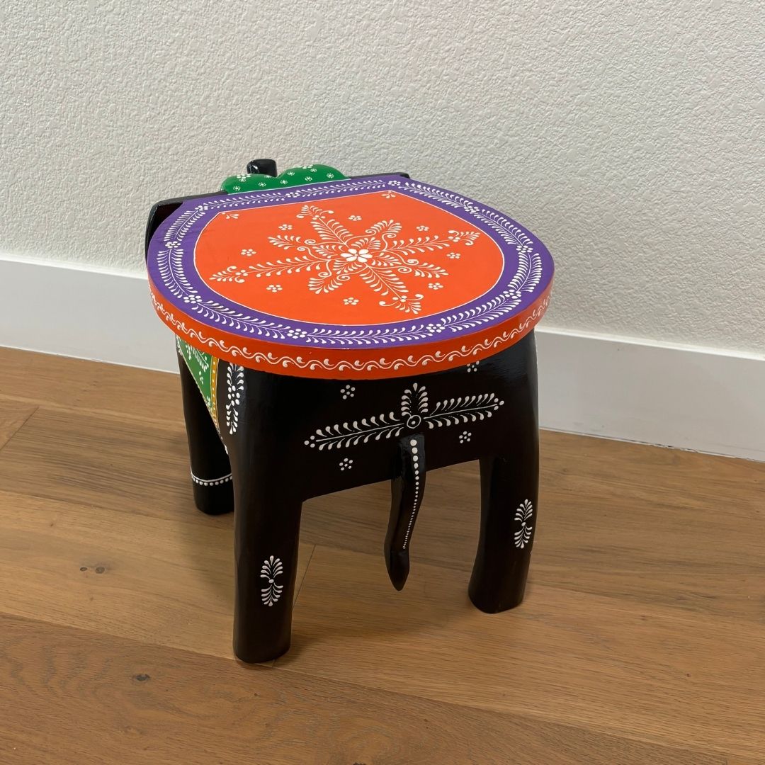 Back view of Wooden elephant stool styled as a coffee table in a cozy living room with modern decor