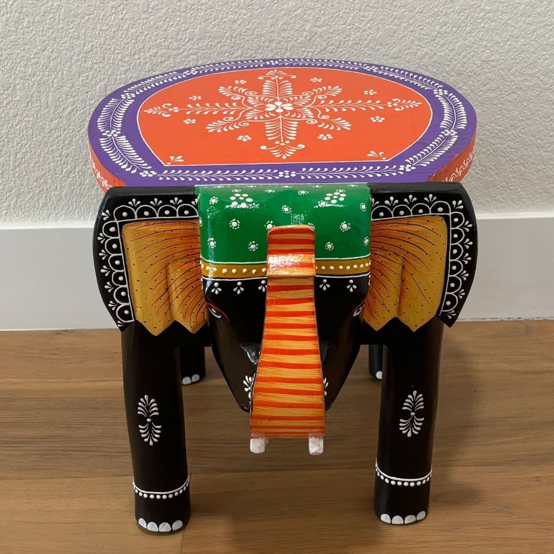 Close-up of the carved legs and textured black finish of the handcrafted elephant bedroom side table