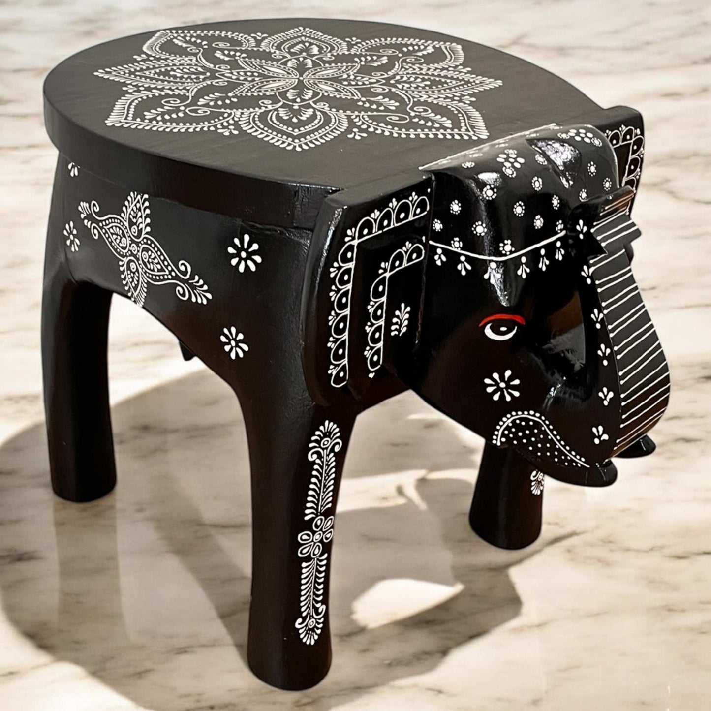 Versatile black elephant side table used as a coffee table in a cozy seating area