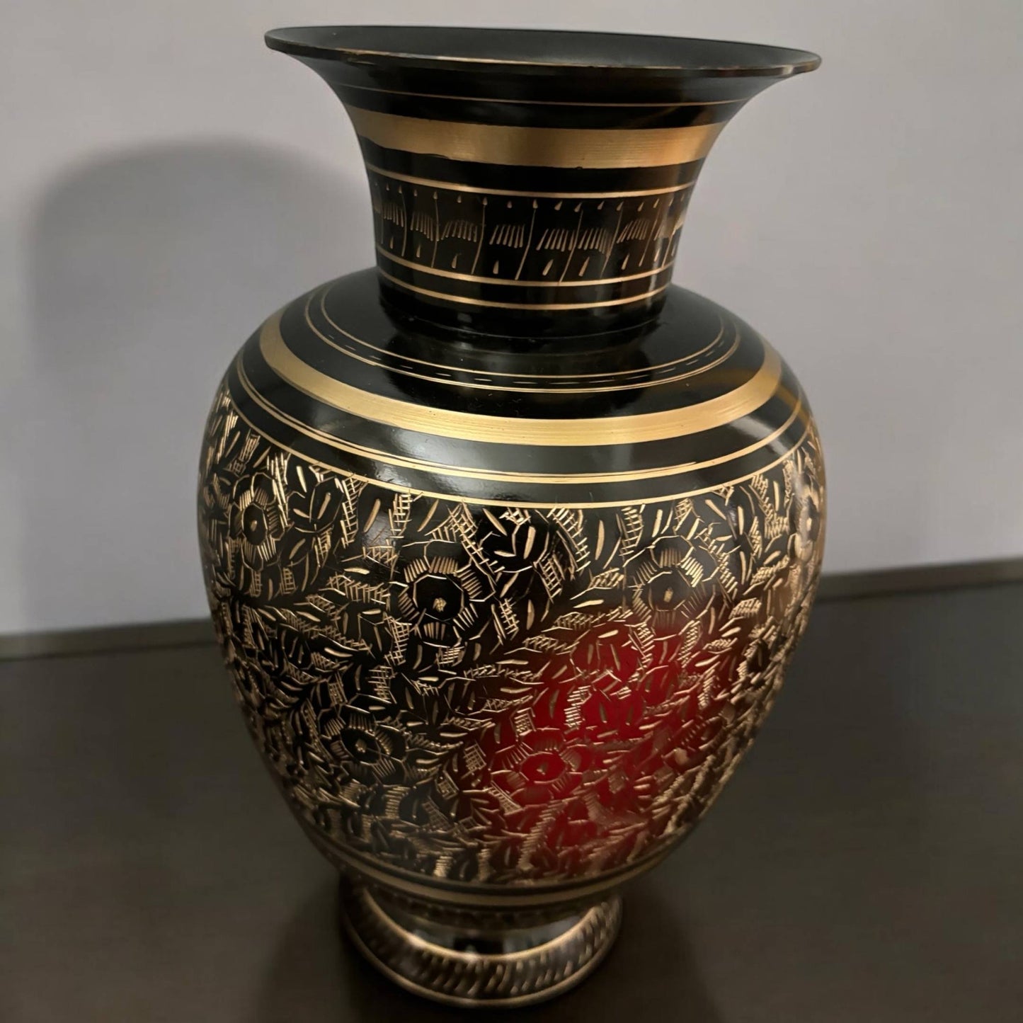 Close-up view of engraved floral etching on black brass vase, showcasing fine craftsmanship