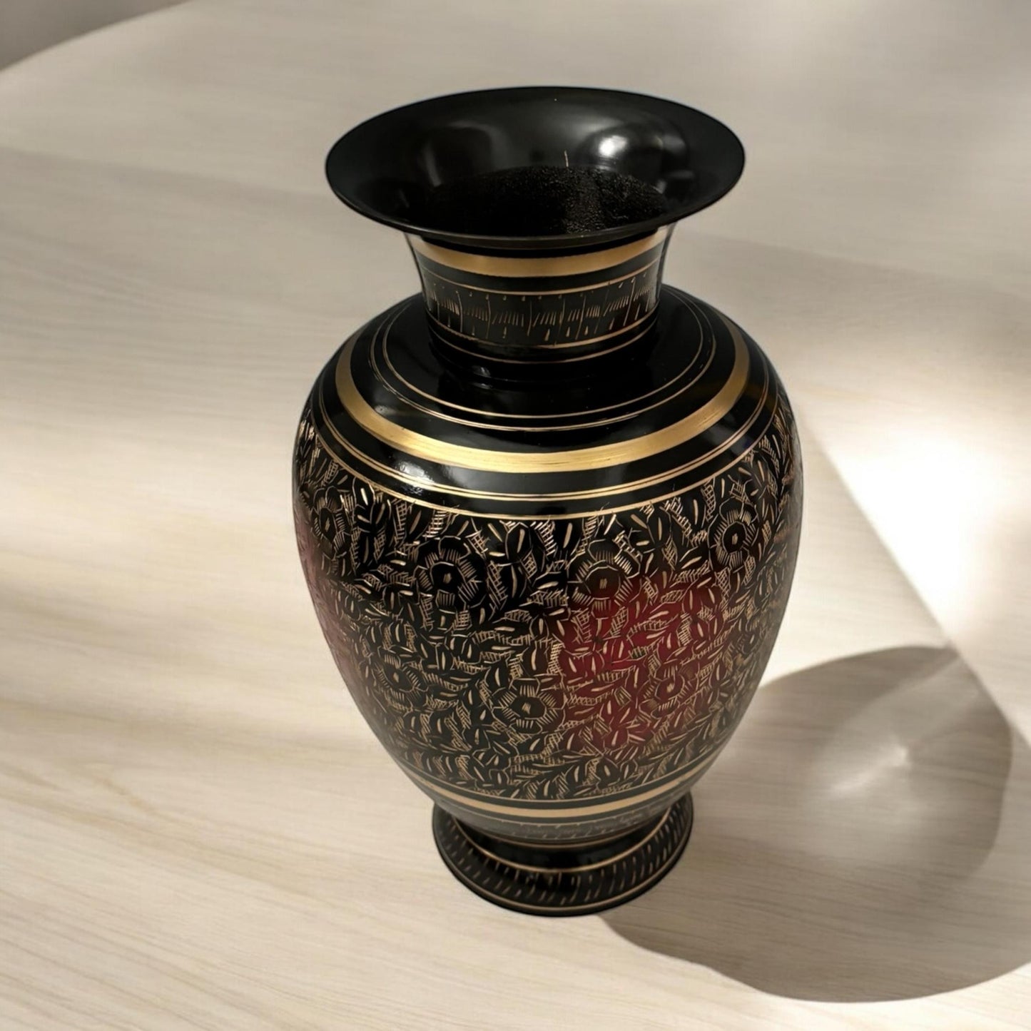 Close-up view of engraved floral etching on black brass vase, showcasing fine craftsmanship
