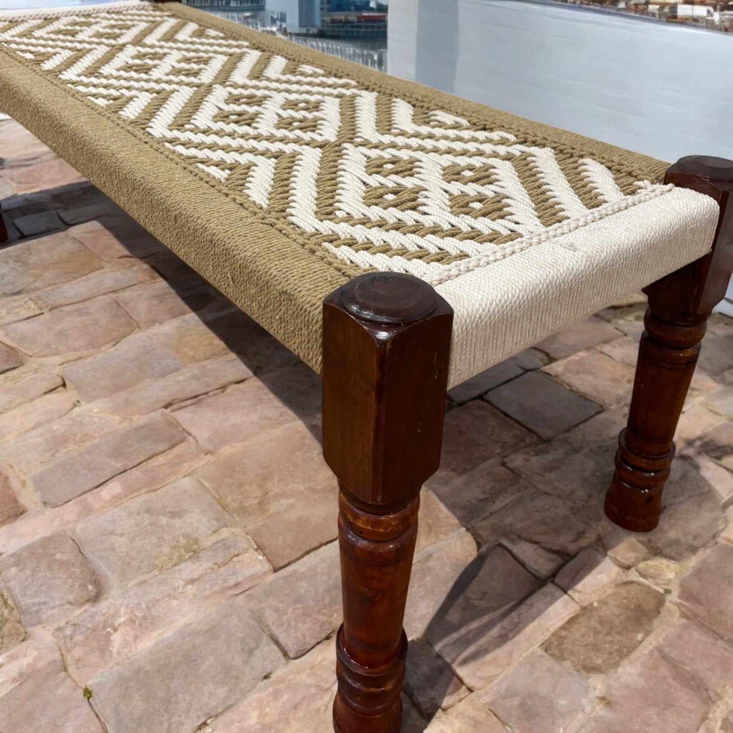 Handwoven Charpai bench with rustic jute cord seating, featuring a sleek silhouette and solid mango wood frame.