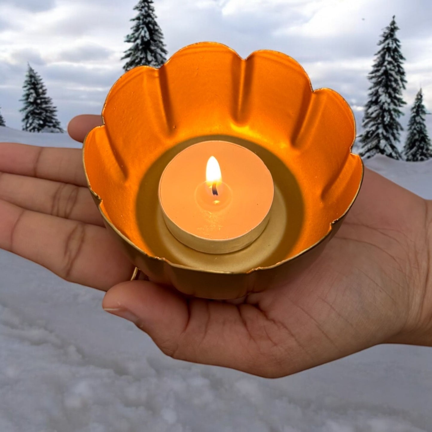 Hand holding a lotus metal diwali diya, demonstrating its compact size and portability for various decor uses