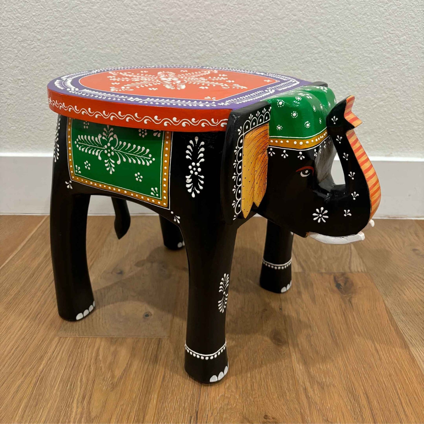 Side view of the black elephant stool showcasing sturdy construction and ornate details