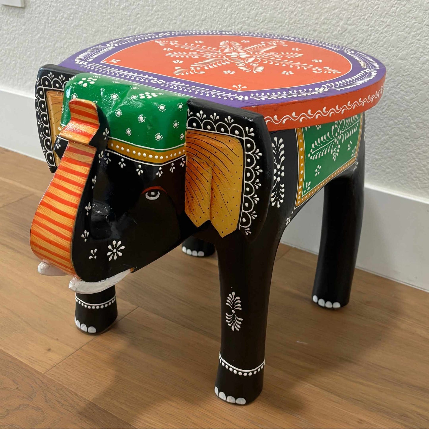 Black Orange elephant stool with intricate carvings, serving as a stylish side or accent table