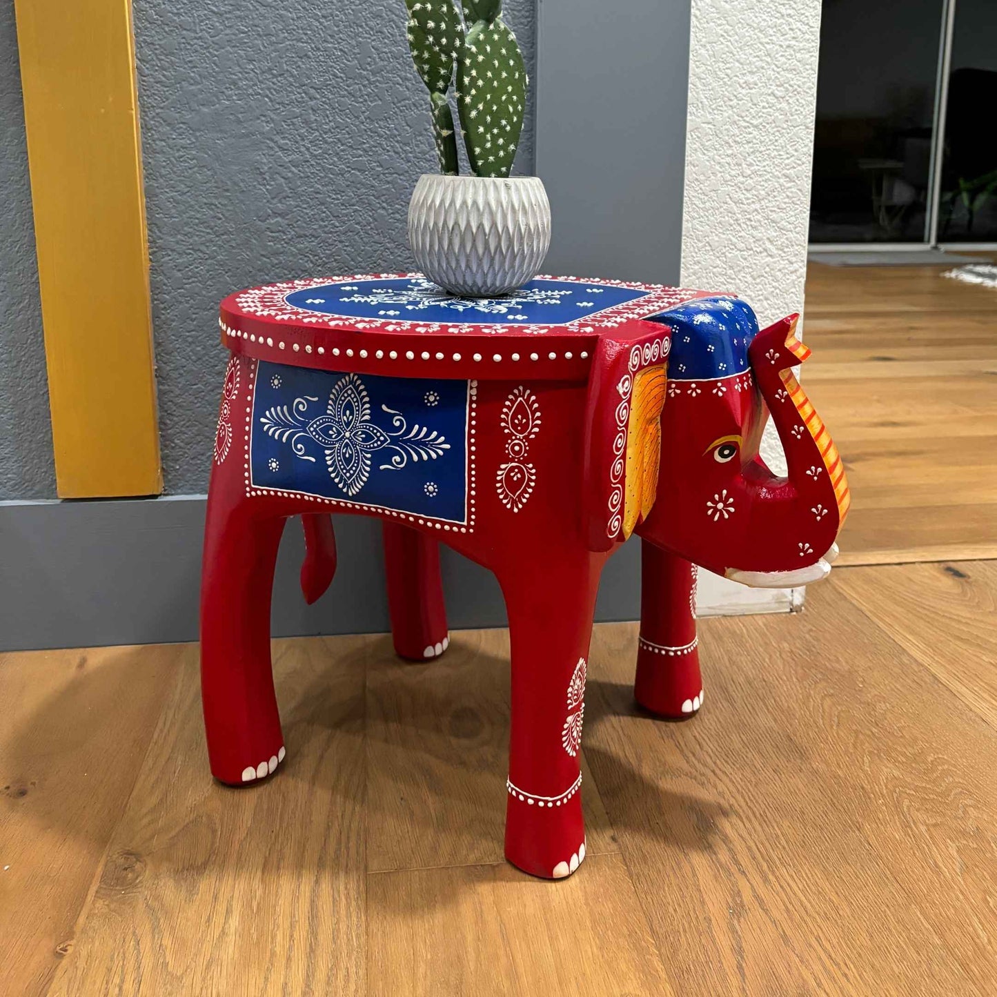 Close-up of intricately carved elephant legs supporting the boho-style wooden side table