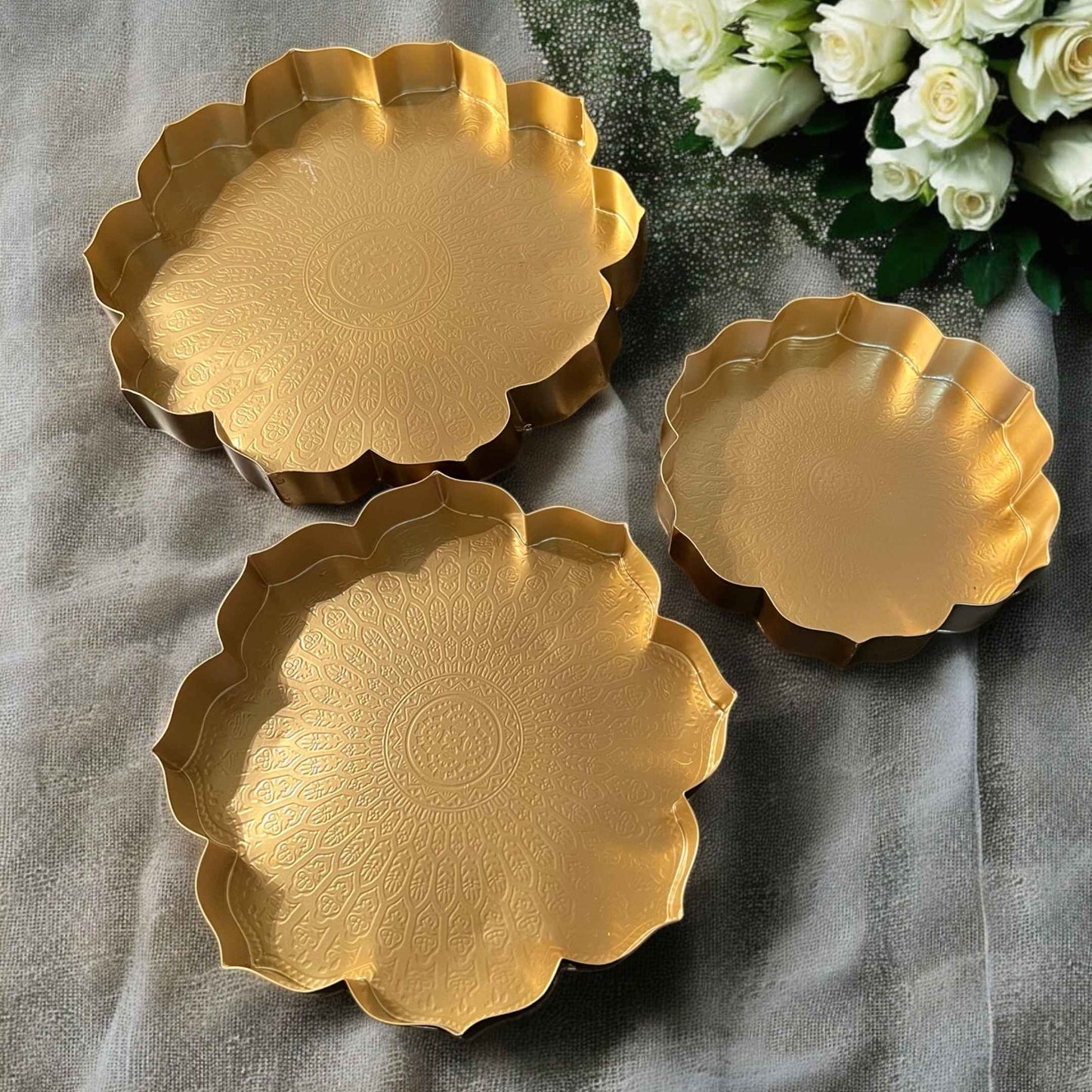 Set of three gold hammered lotus urli bowls in small, medium, and large sizes, displayed together on a white background