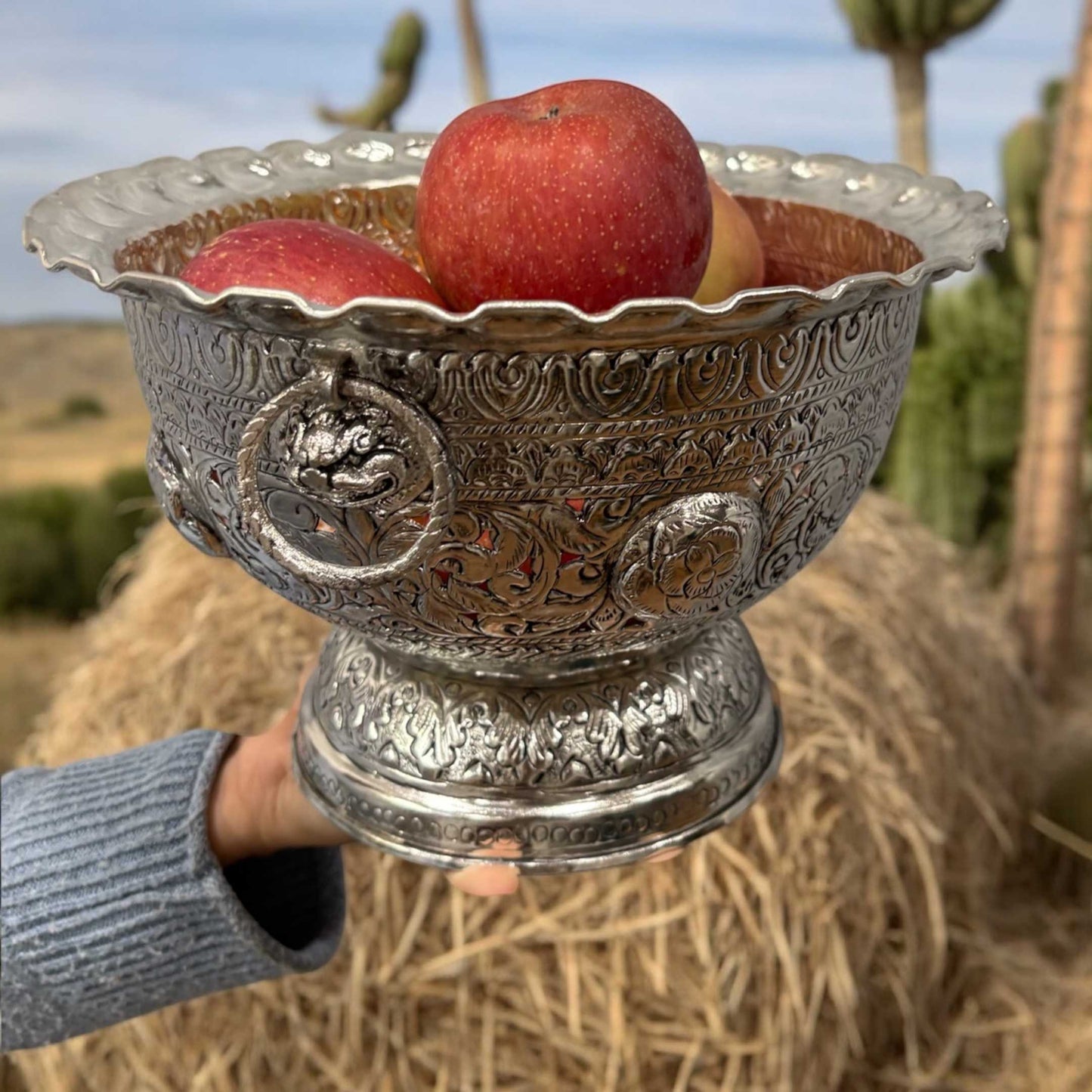 The antique silver fruit bowl filled with an assortment of colorful fruits, highlighting its functionality and aesthetic appeal as a centerpiece