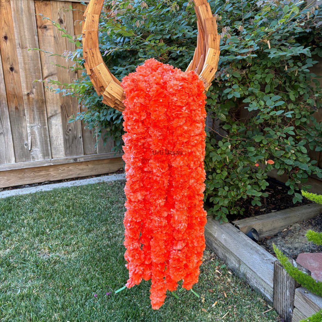A set of ten orange artificial marigold garlands from Urli Utsav Decor, priced approx $2 per string