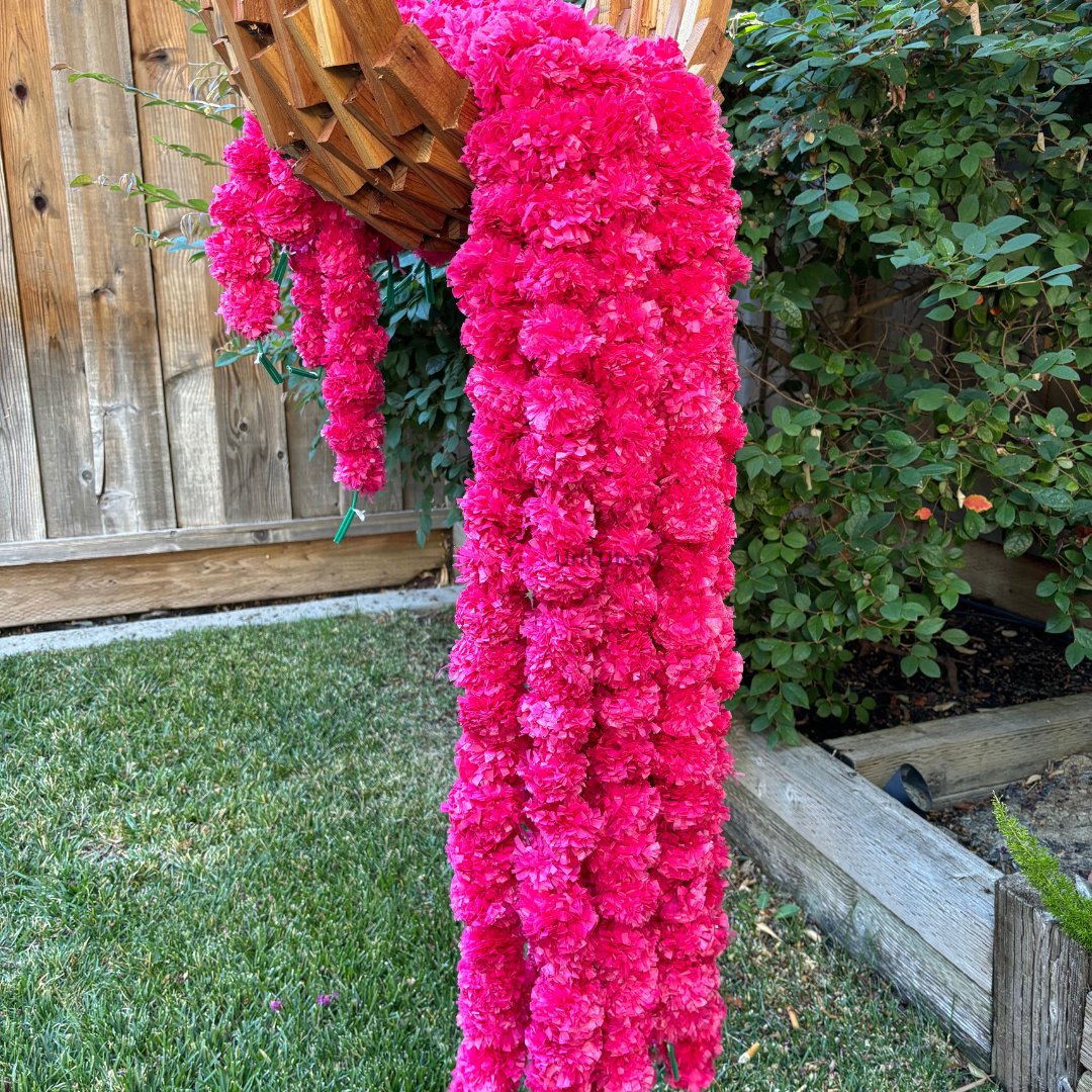 A set of ten pink artificial marigold garlands from Urli Utsav Decor, priced approx $2 per string