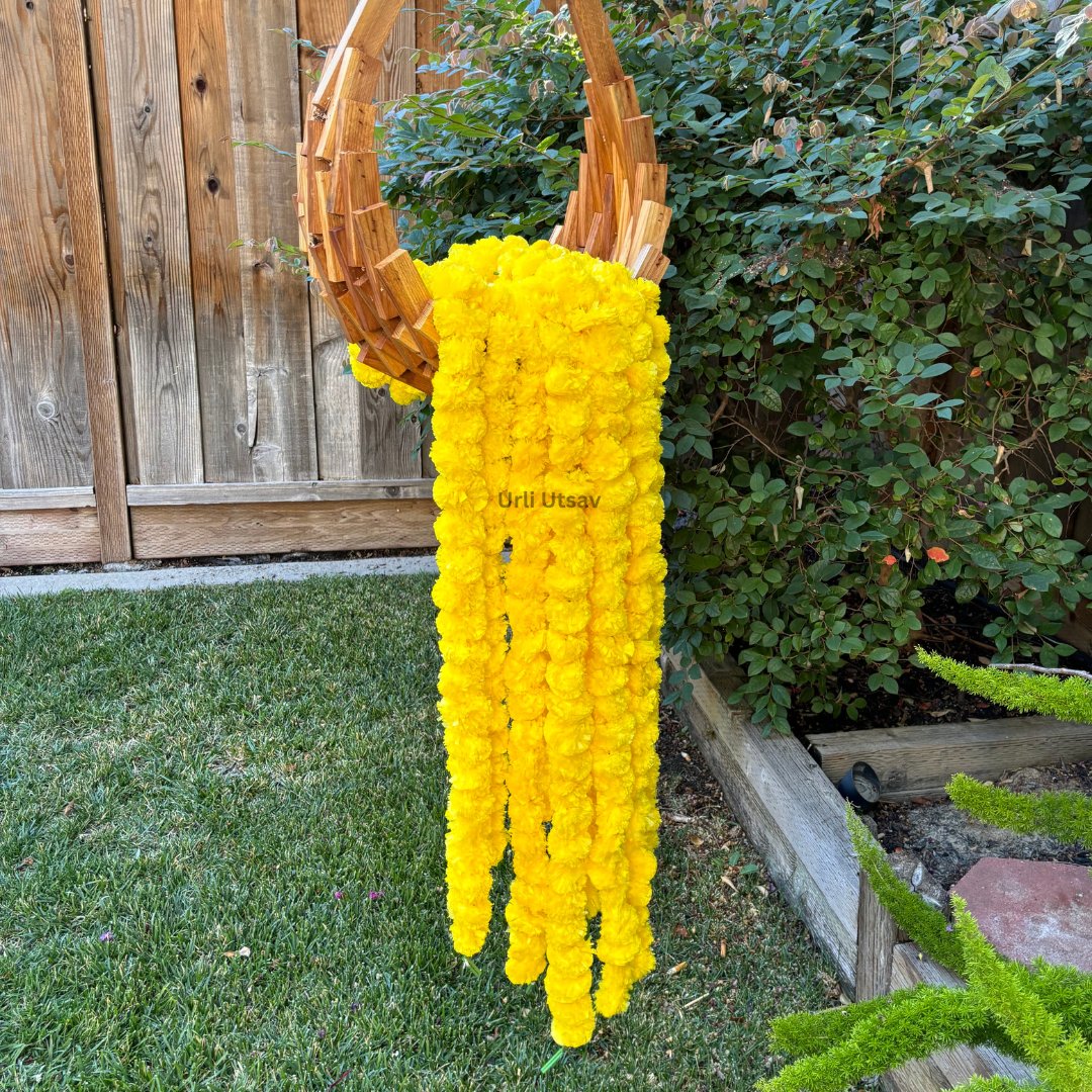 A set of ten yellow artificial marigold garlands from Urli Utsav Decor, priced approx $2 per string