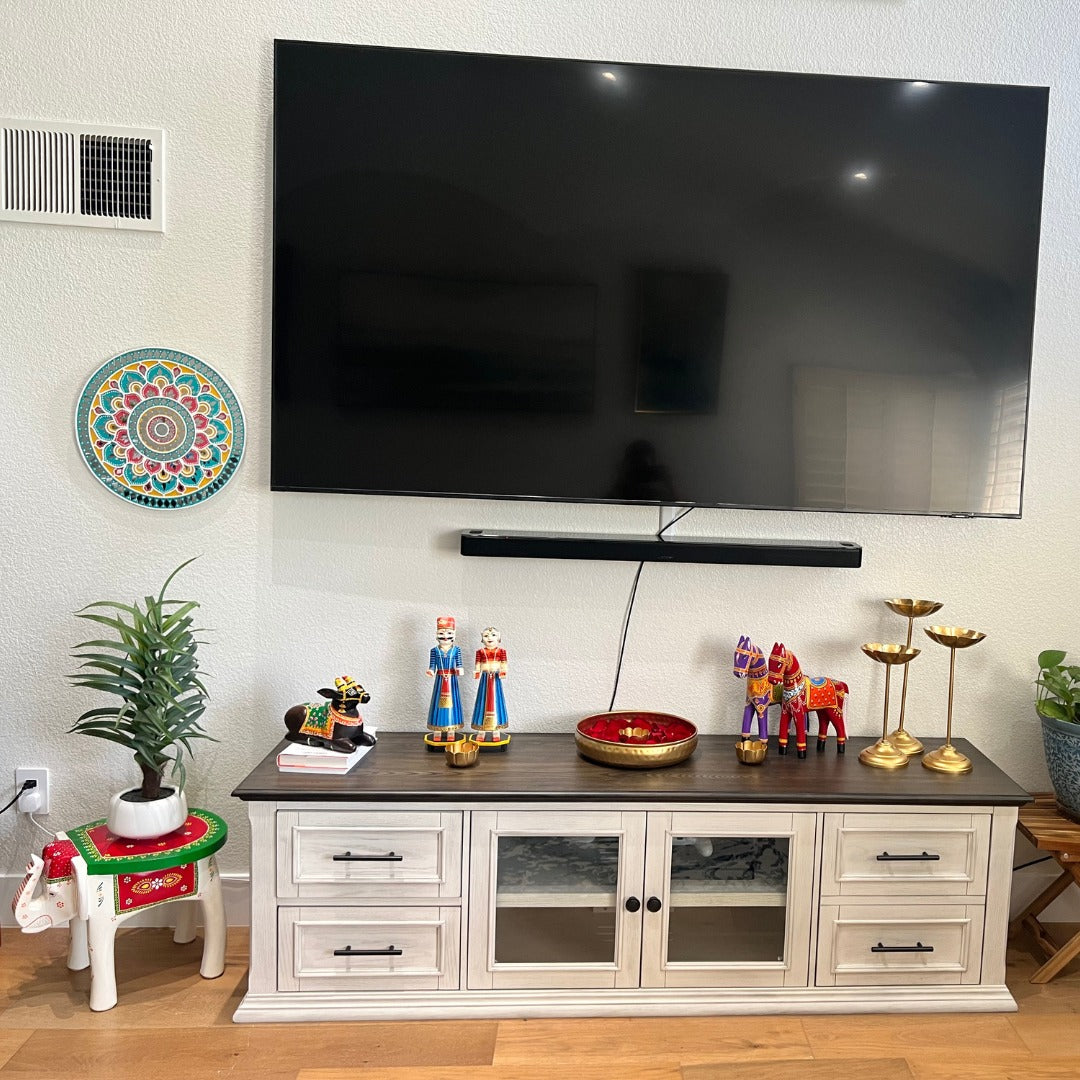 Rustic-style wooden horse statue adding charm to a shelf display. Elephant stool displayed as a stylish accent table in a modern living room setting