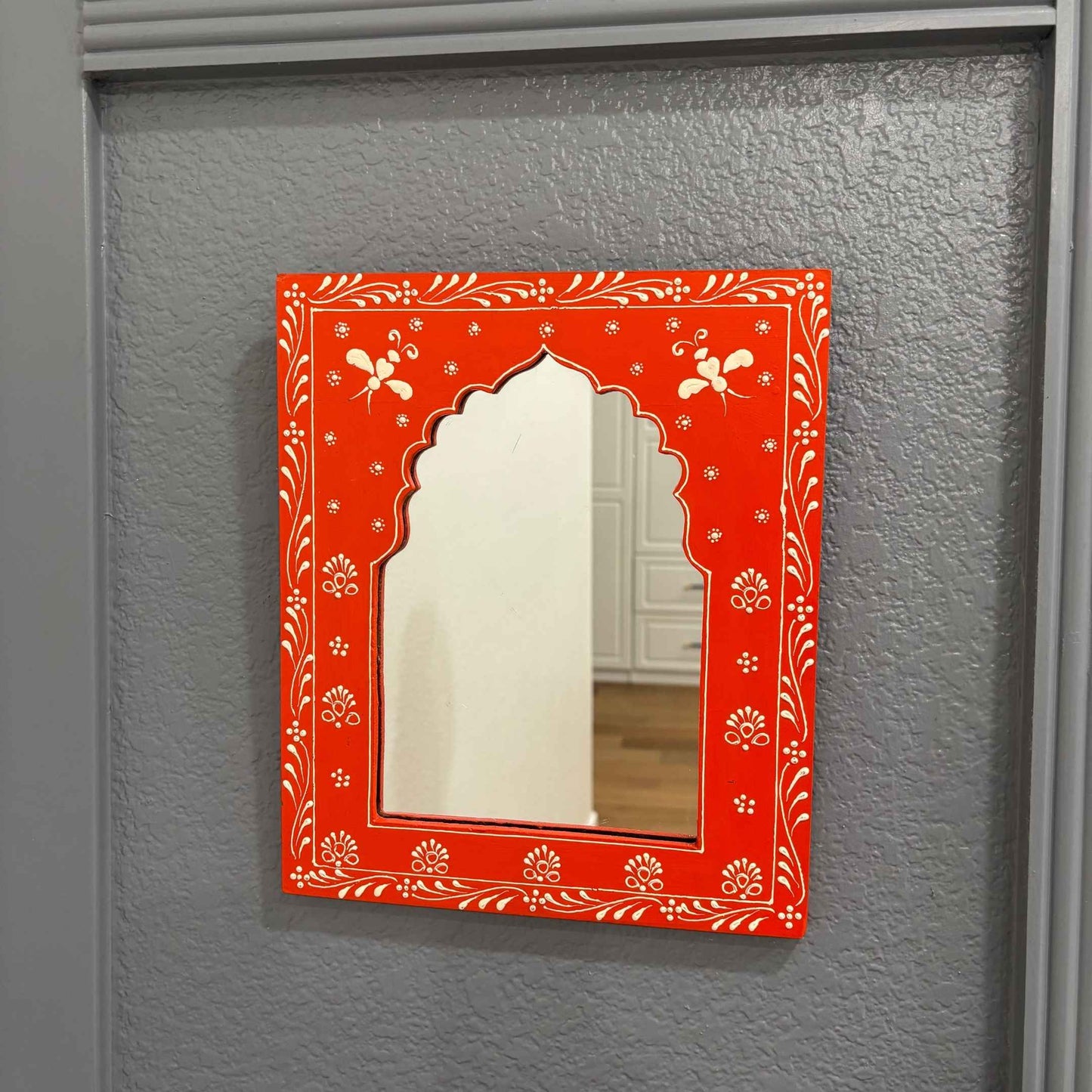 Hand-painted 12x10-inch Orange Jharokha mirror in Rajasthani style from Urli Utsav, highlighting its ornate frame and mirror quality