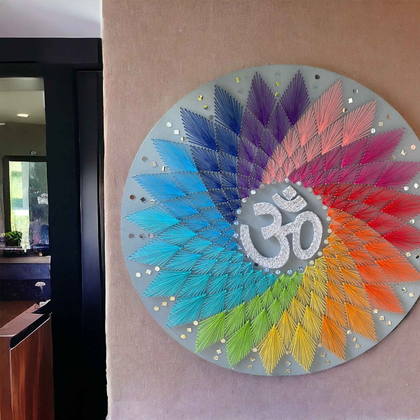 The string art piece displayed on a shelf, highlighting its versatility in home decor