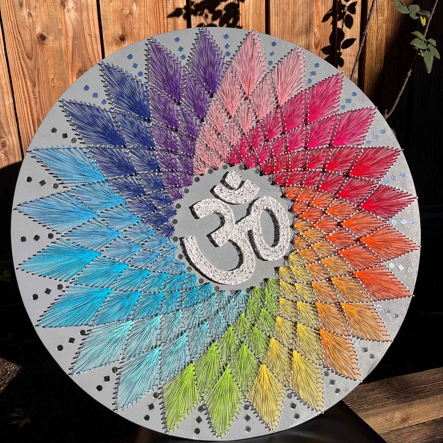 The string art piece displayed on a shelf, highlighting its versatility in home decor