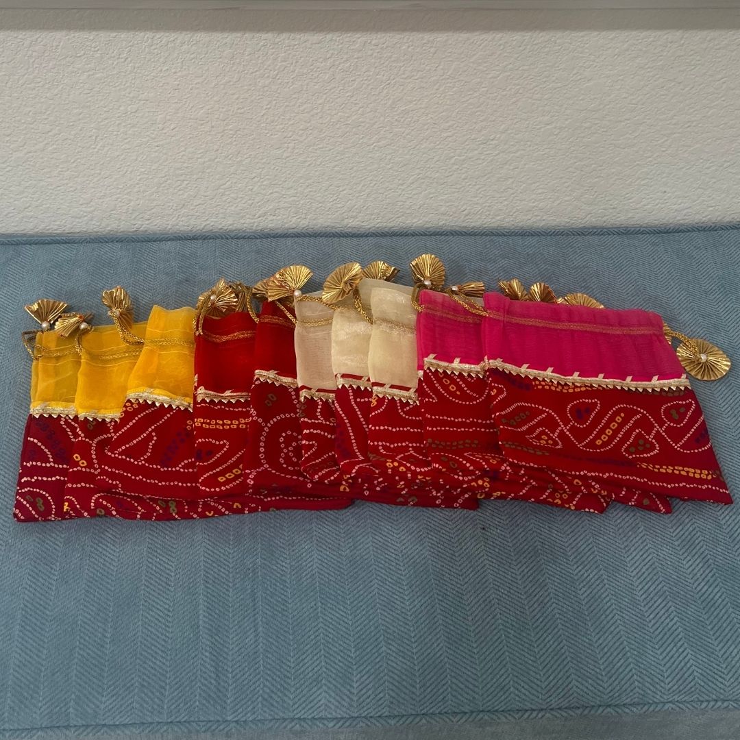 Decorative fabric with red, pink, and gold patterns on a blue surface.