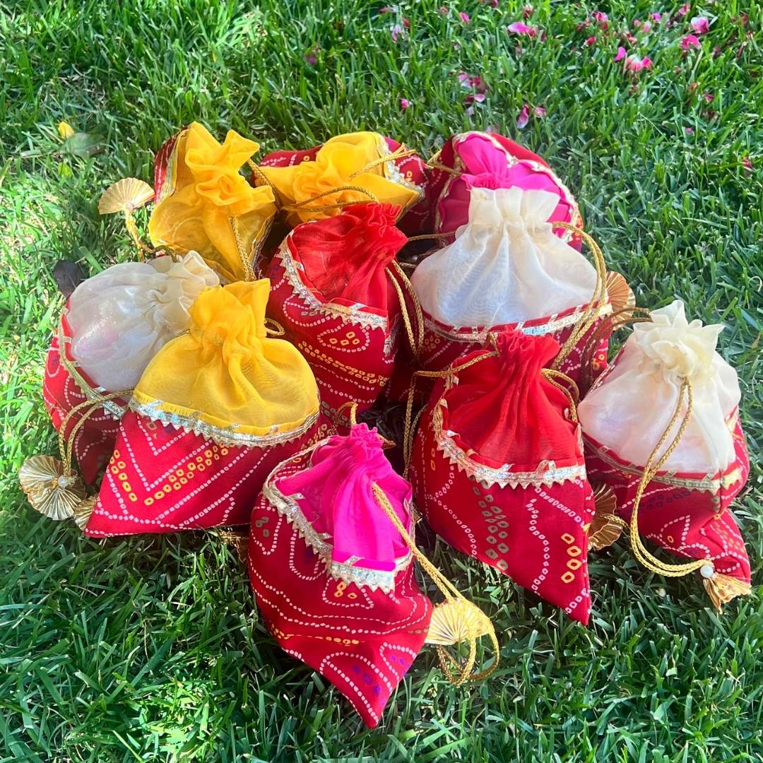 Colorful fabric bags with decorative elements on a grassy background