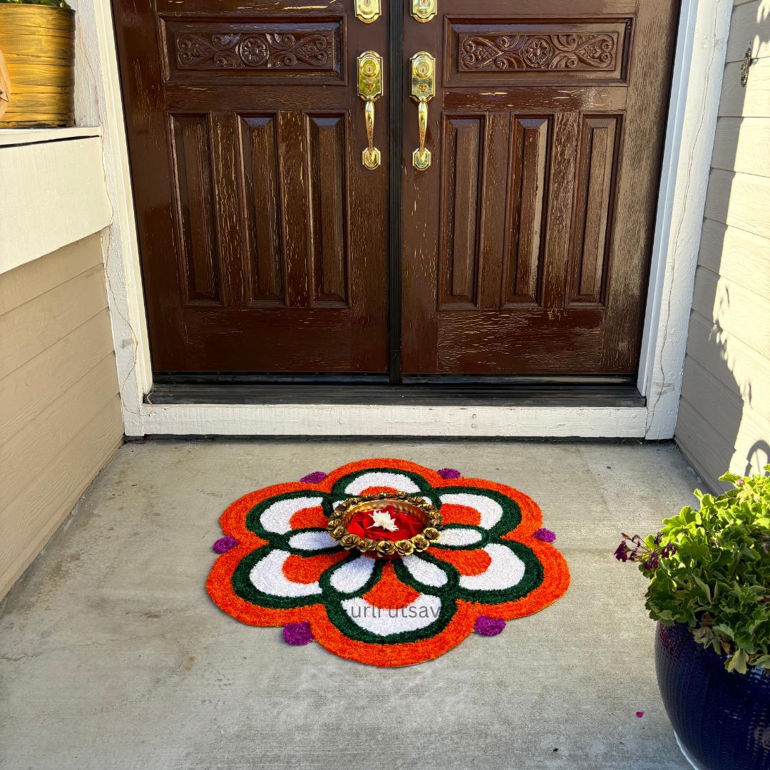 Circular rangoli mat in red, white, yellow and green, placed at a home entrance, showcasing a floral petal design