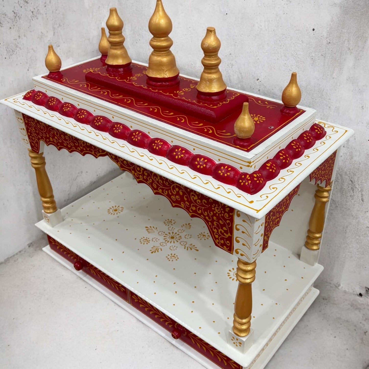 Red pooja temple with a classic Indian design, ideal for home decor