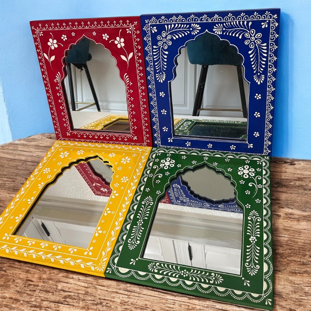 Collection of four hand-painted Jharokha mirrors from Urli Utsav, each featuring unique color schemes and designs