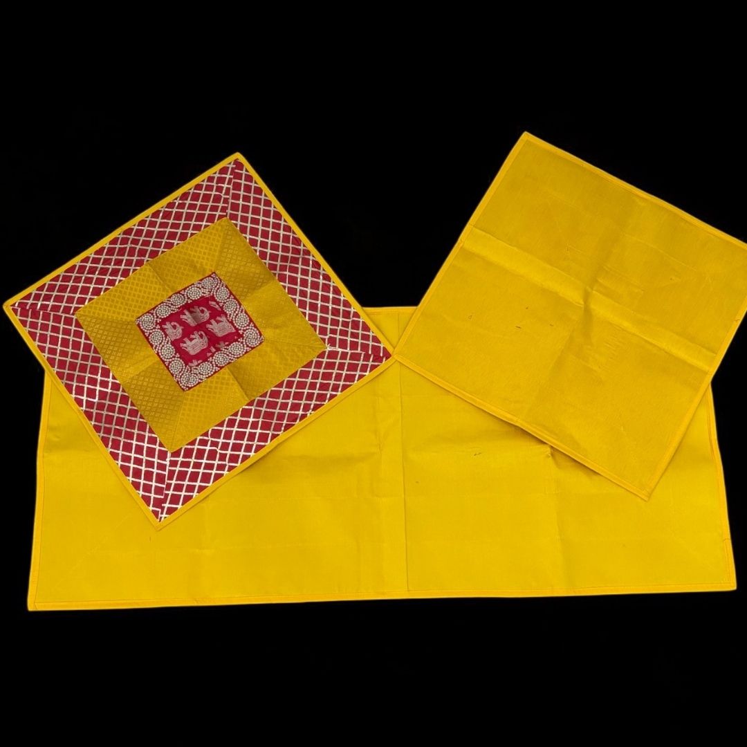 Yellow fabric with a red and gold embroidered square on a black background