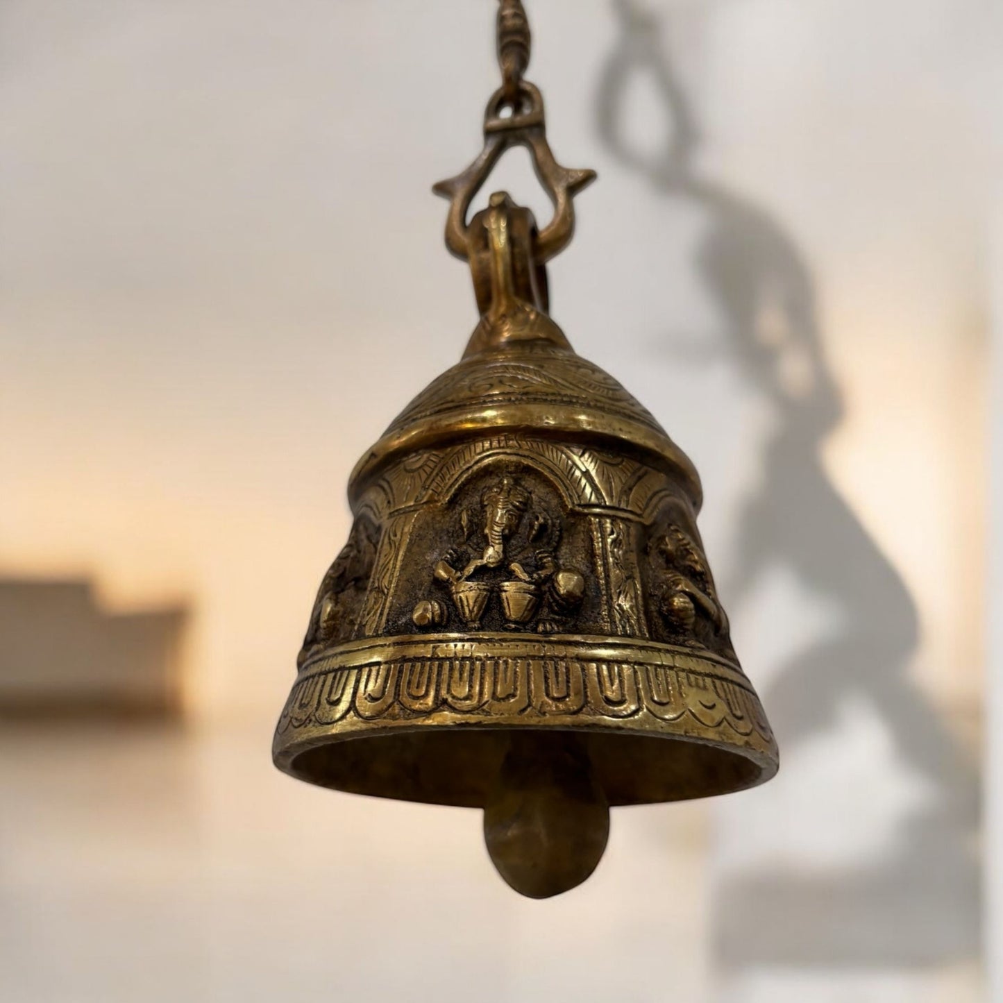 Bottom angle focusing on the interior of the bell, illustrating the clapper and the quality of the brass finish
