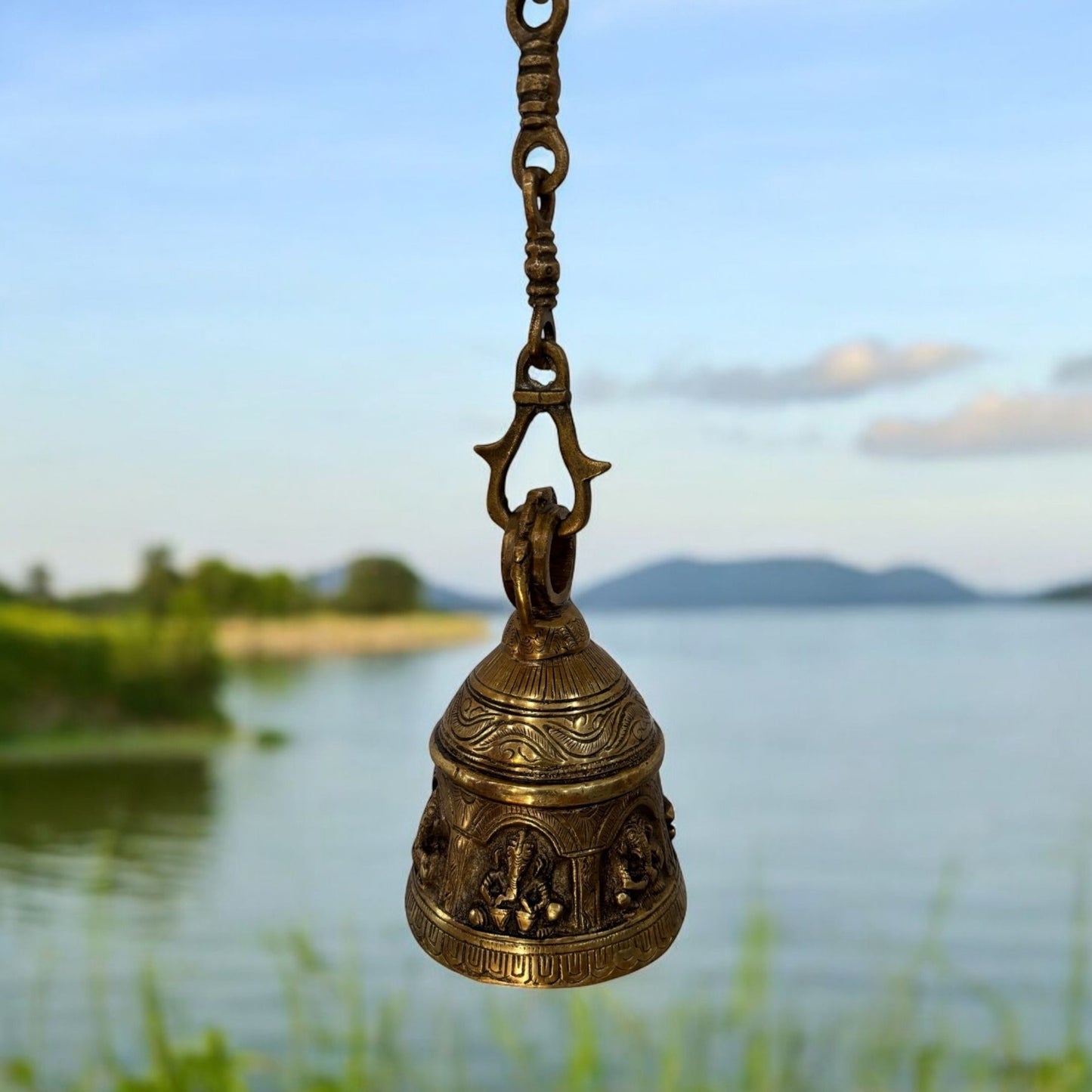 The brass hanging bell mounted at a home's entrance, exemplifying its role in welcoming positive energy and serving as a housewarming gift