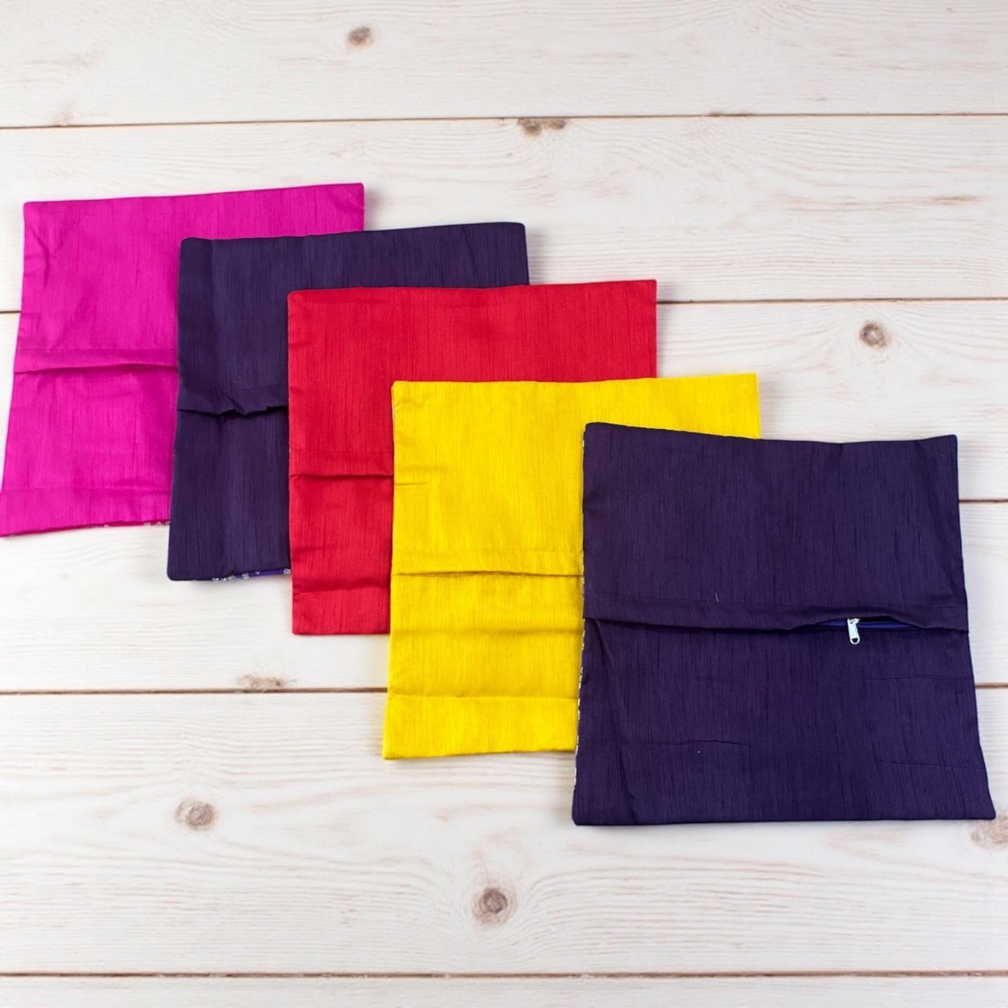 Set of colorful fabric envelopes on a wooden surface