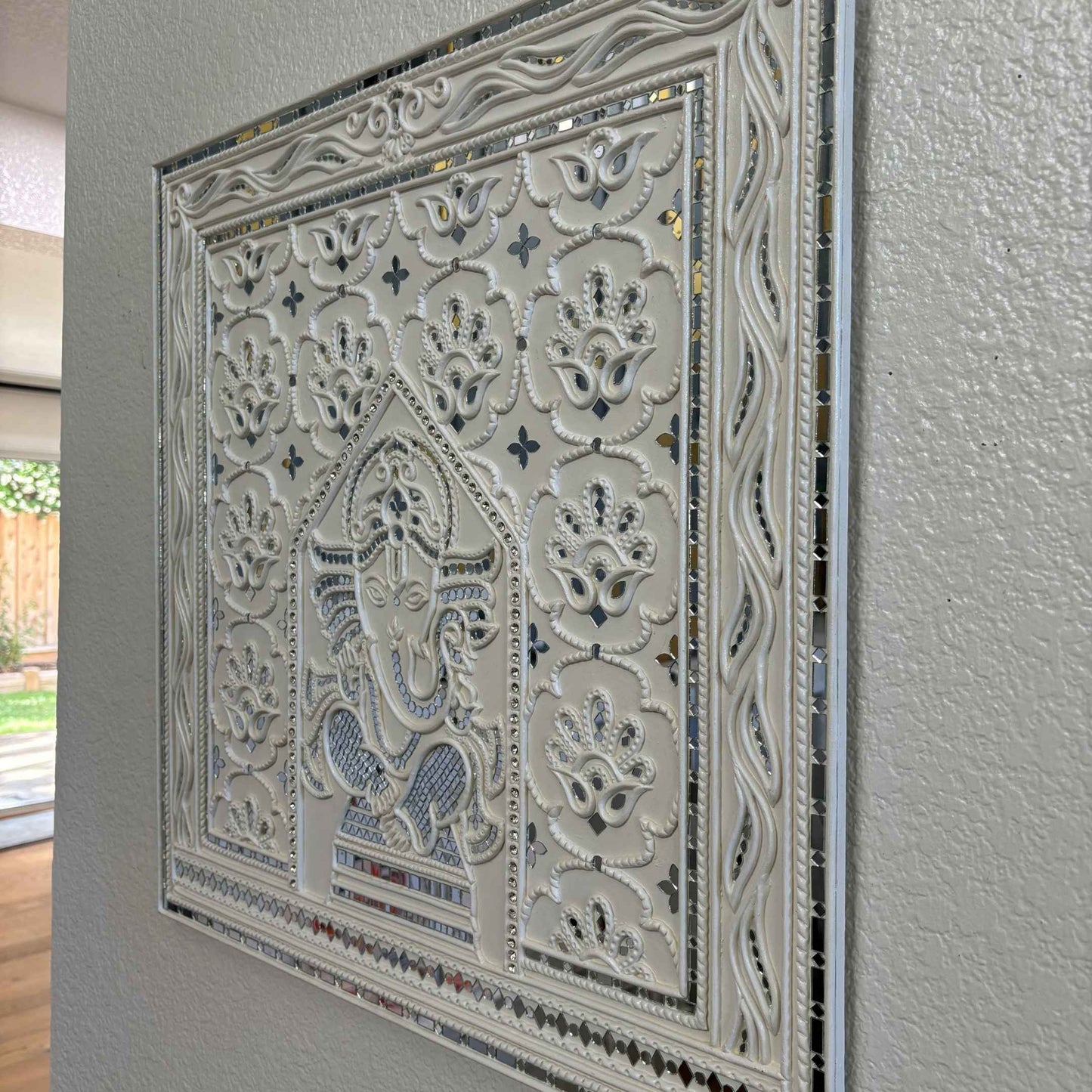 Decorative Ganesha Lippan wall art with intricate design on white wall