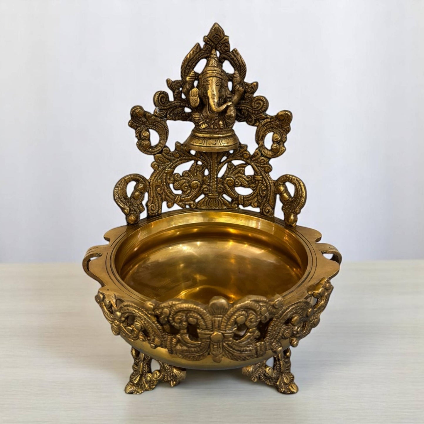 Close-up view of the handcrafted brass Ganesha idol atop the Traditional Brass Ganesh Urli Bowl, showcasing intricate detailing suitable for diya stand urli and festive home decor