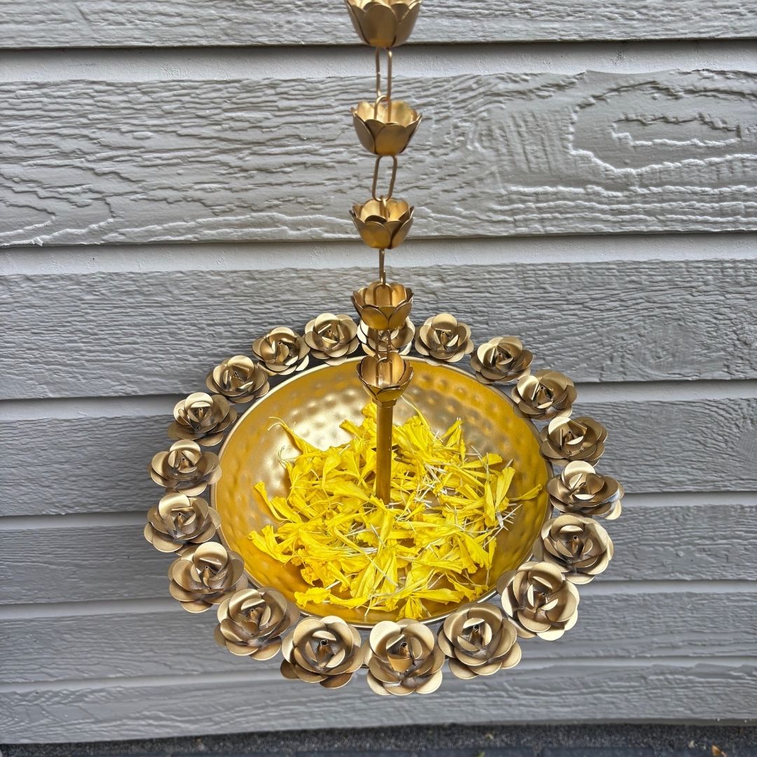 Closeup look of rose hanging urli, Gold chain with decorative design on a gray wooden background