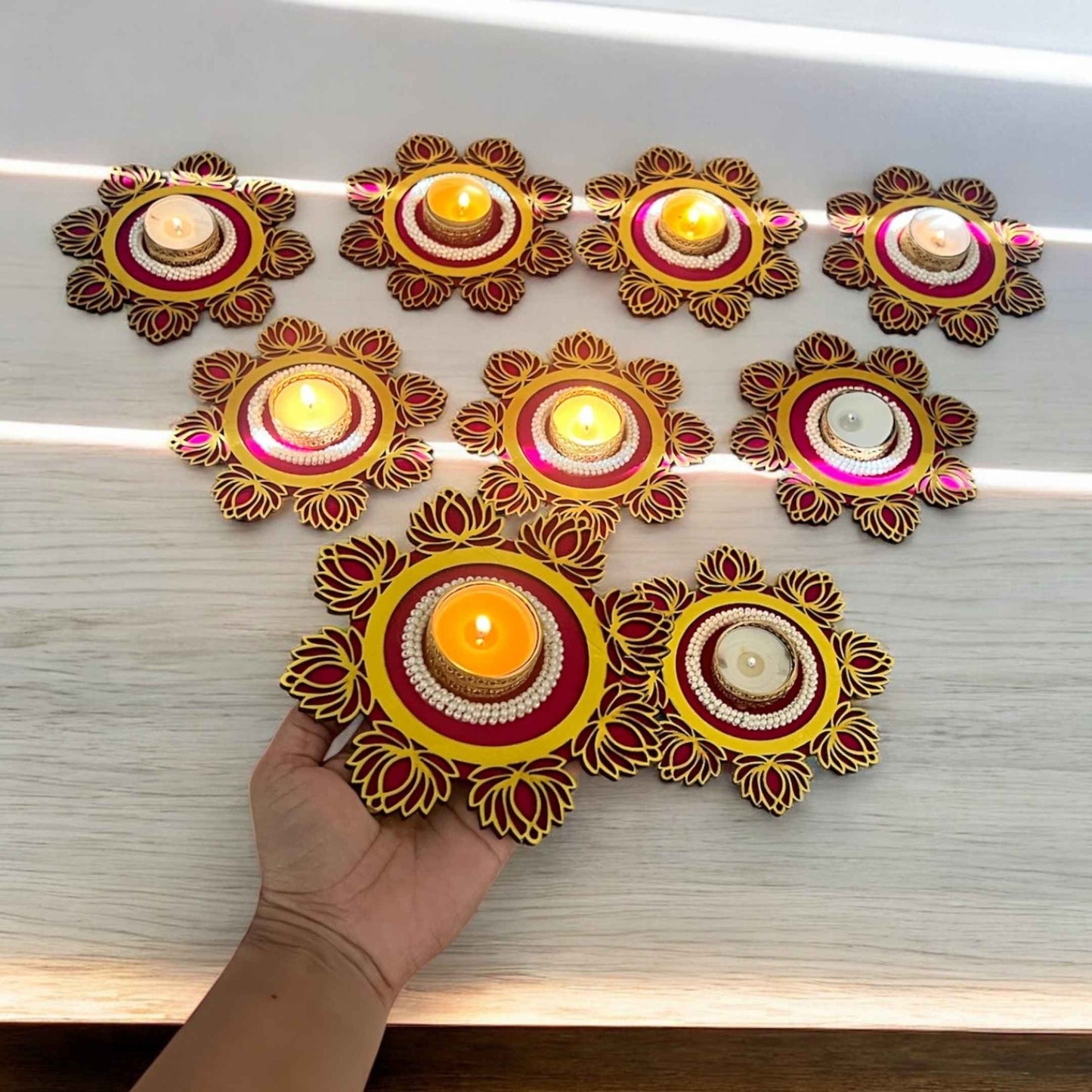 Decorative candle holders with candles on a wooden surface