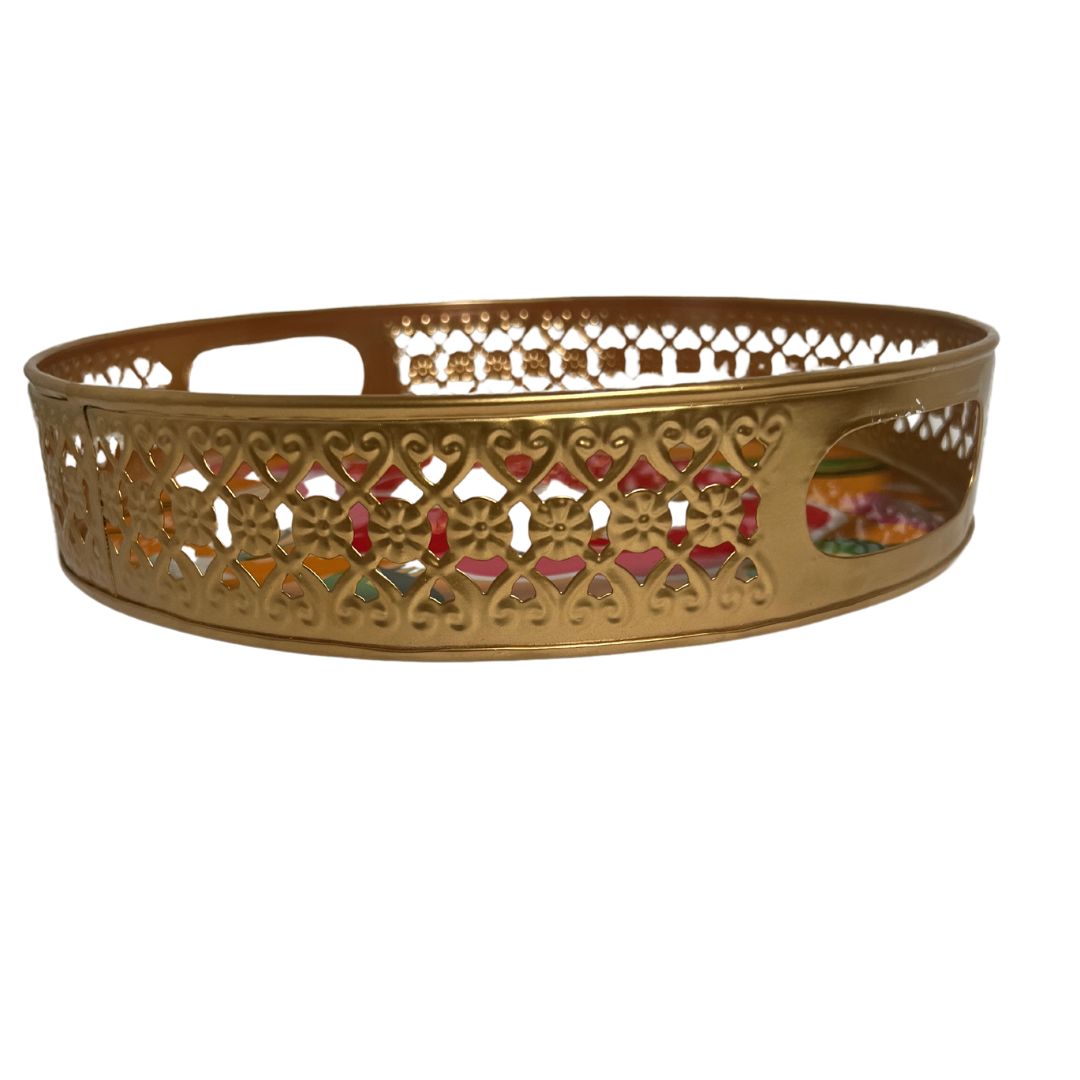 Side‑on profile of a single gold-toned metal tray with delicate cut‑out edge detailing, set against a plain white background to emphasize craftsmanship.