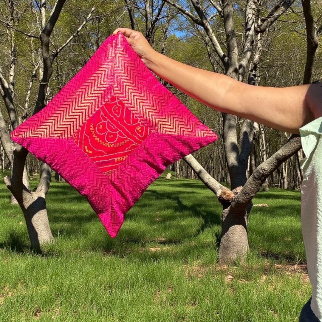 Handheld view of pink Bandhani-patterned textile for 16×16 cushion cover — shows scale and texture.