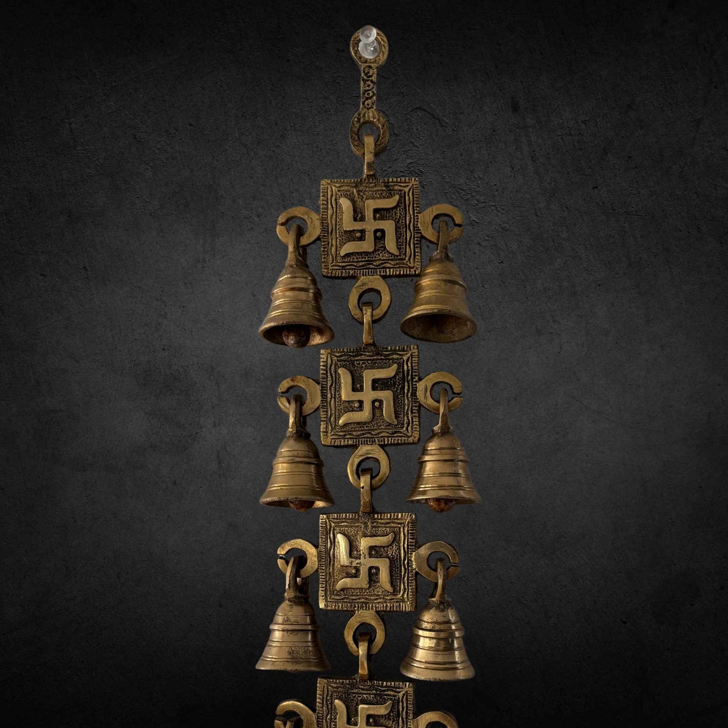 A handcrafted 15-inch brass Swastik wall hanging featuring intricate engravings and a polished gold finish, symbolizing prosperity and positive energy