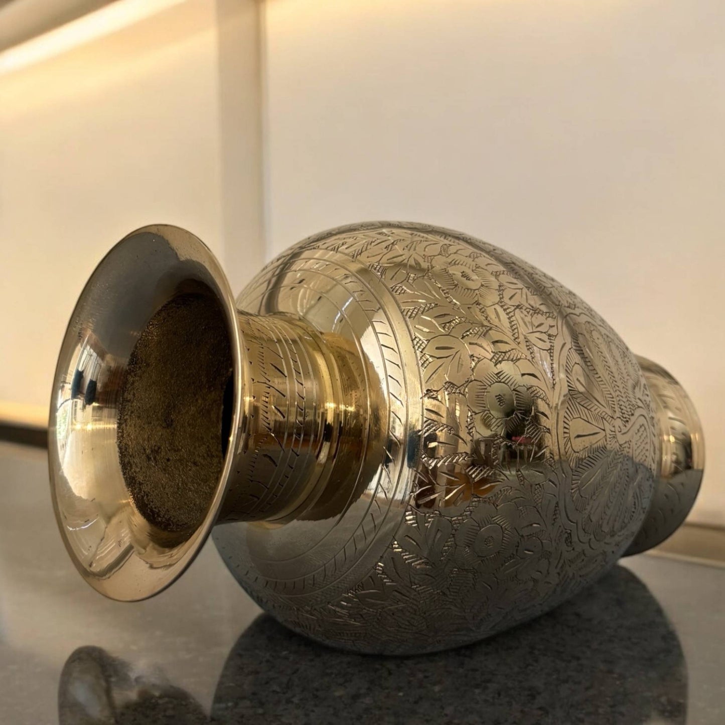 Side profile of the brass vase showcasing its elegant curvature and detailed hand-engraved patterns