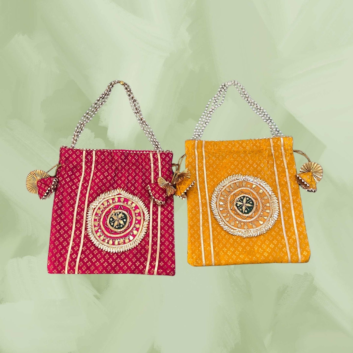 Two colorful handbags, one red and one orange, with decorative patterns on a light green background.