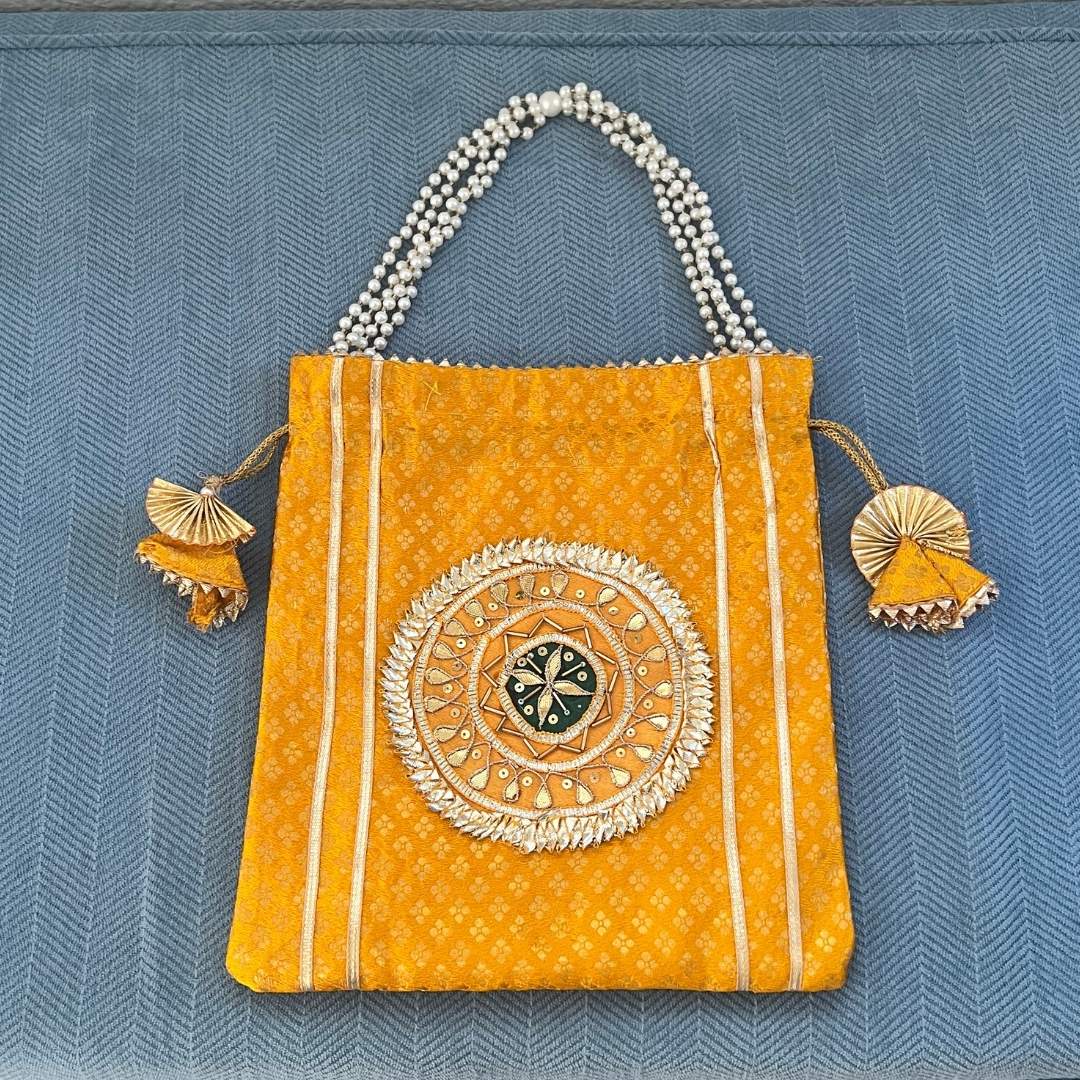Decorative handbag with intricate design on a blue textured background