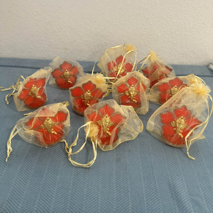 Ten Ganesha car idols each packed in a sheer gold drawstring potli bag for return gifts