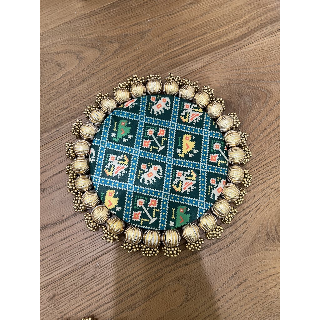 Round Patola brocade mat in deep teal, patterned with a grid of elephants and figures inside a gold beaded border.