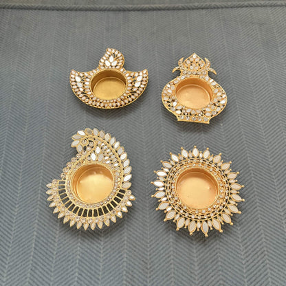 All four mirror diya designs side by side, unlit: deep, kalash, mango paisley and sunflower