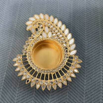 Close-up of a gold mirror mango paisley tea light holder with white stones and a pierced fan base