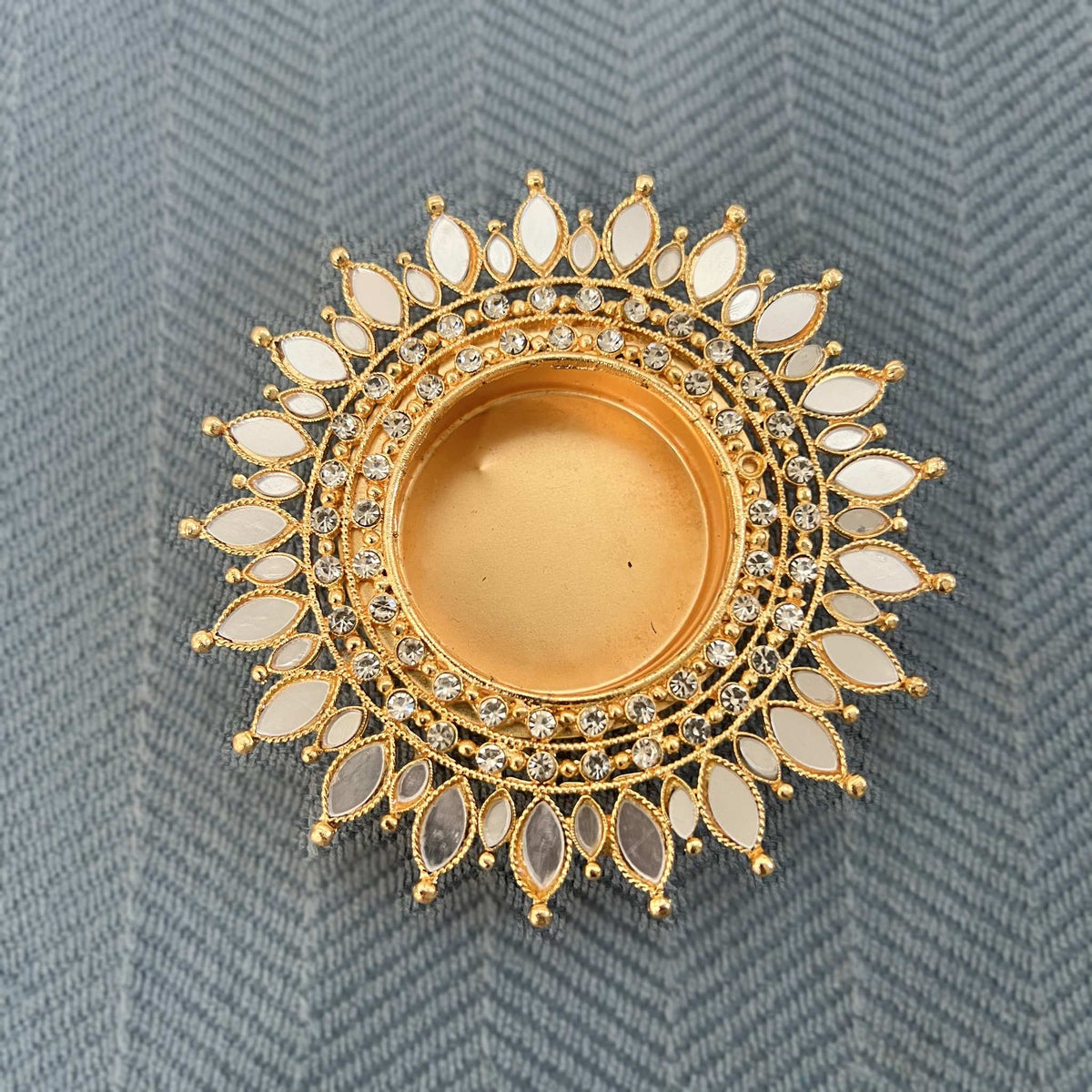 Close-up of a gold mirror sunflower tea light holder with radiating white mirror petals