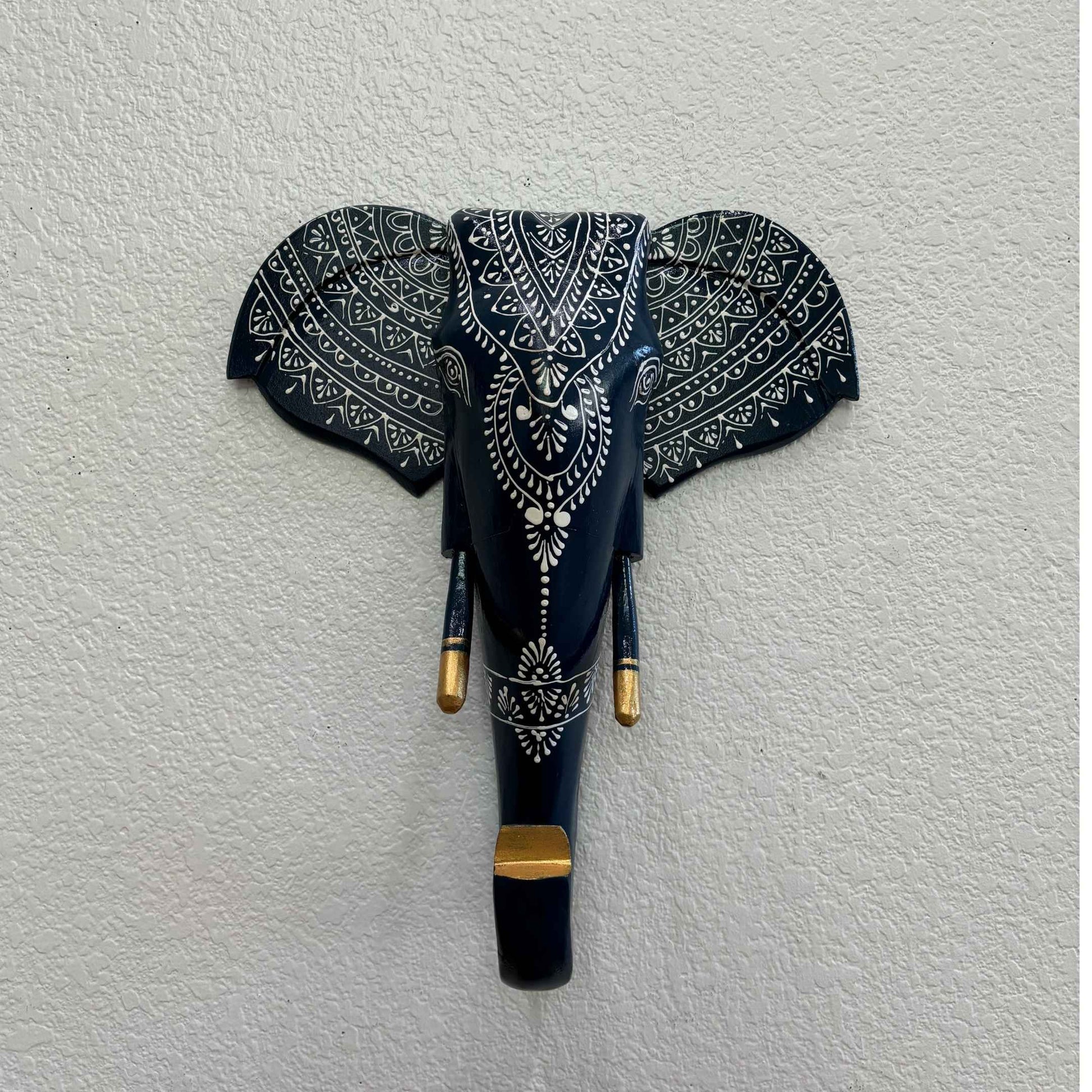 The wooden nile blue elephant head displayed on a living room wall as a statement decor piece