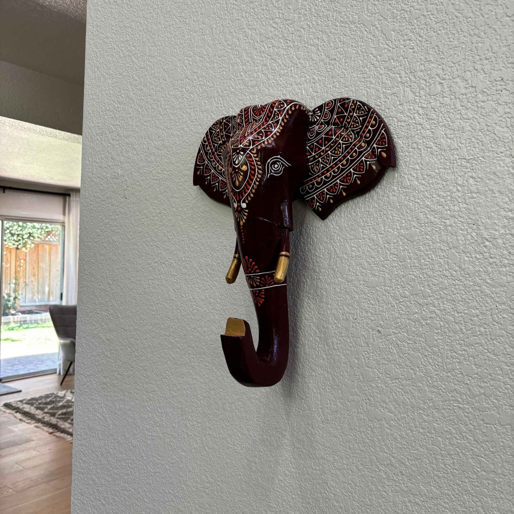 Vivid brown hand-painted colors on the wooden elephant head adding ethnic charm to any space