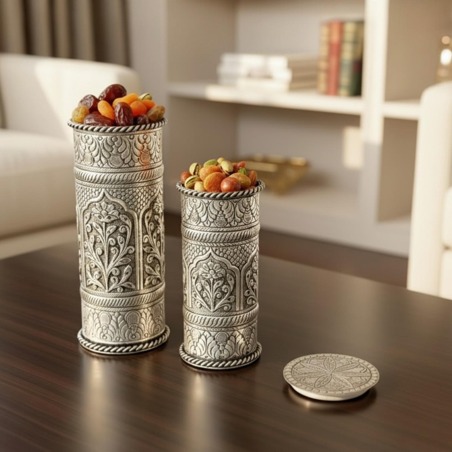Decorative silver containers with fruit on a wooden table, blurred background