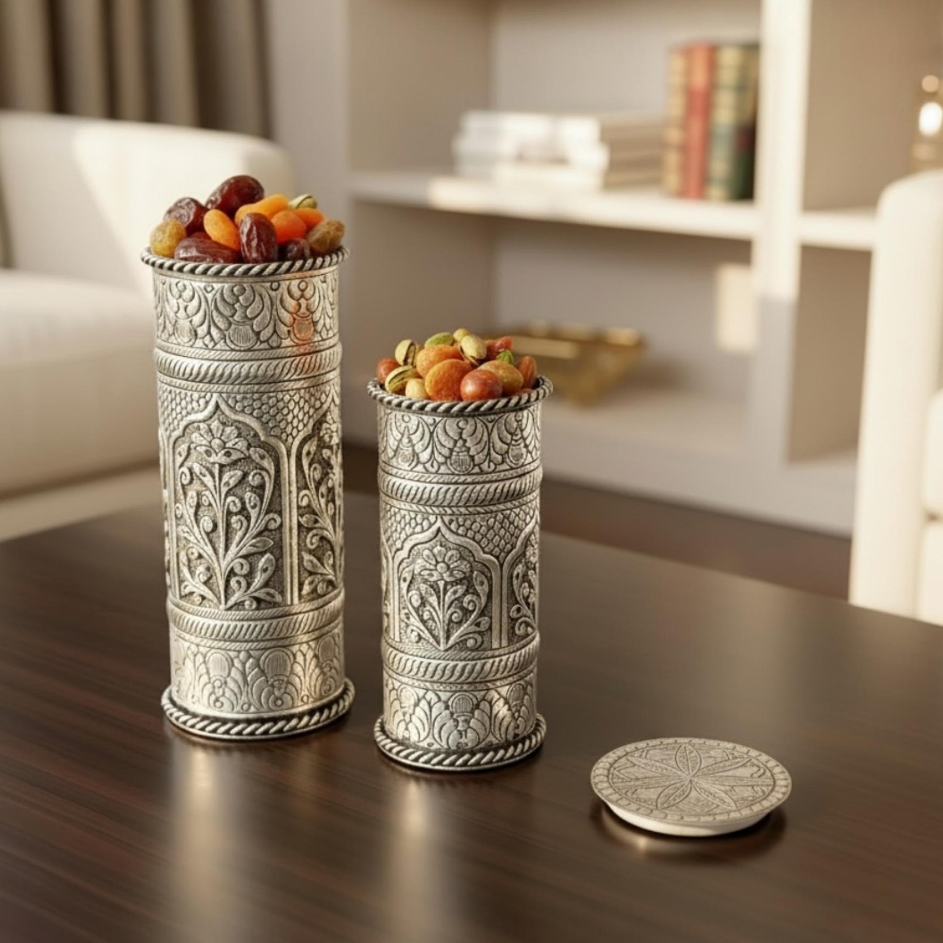 Decorative silver containers with fruit on a wooden table, blurred background