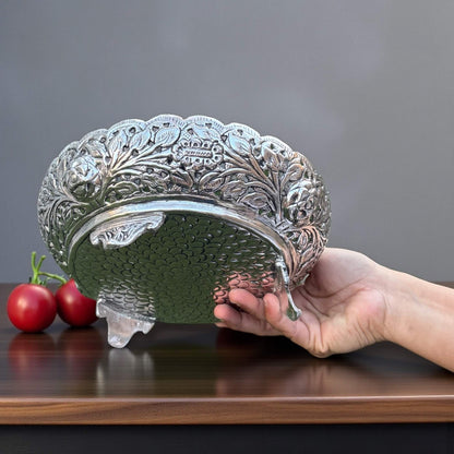 Decorative metal fruit bowl held by hand on wooden surface – German silver antique silver bowl