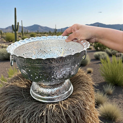 Silver fruit bowl held in desert setting with cacti and mountains – Urli Utsav decor