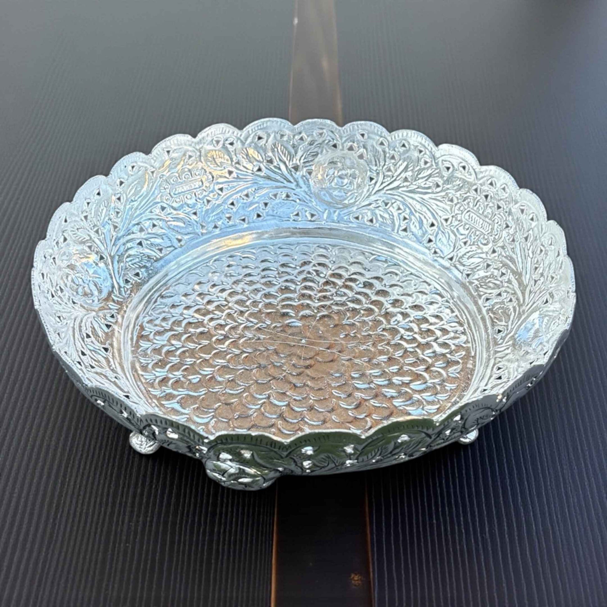 Close-up of German silver fruit bowl intricate antique silver pattern reflective surface